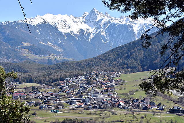 Ansicht von der österreichischen Partnerstadt Roppen mit schneebedeckten Berggipfeln im Hintergrund.