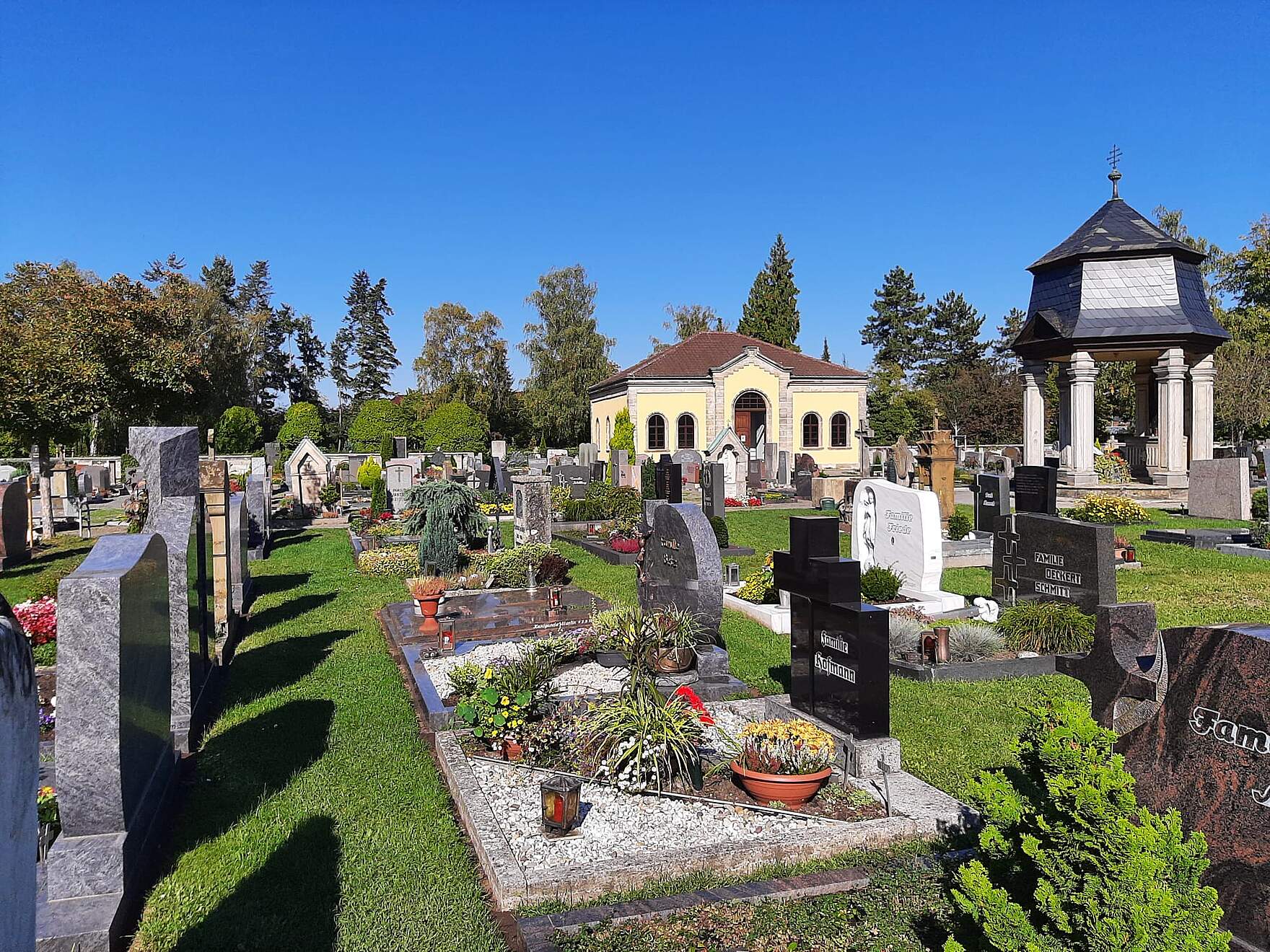Kolumbarium und Dechant-Reuder-Kapelle im Alten Friedhof Kolumbarium und Dechant-Reuder-Kapelle im Alten Friedhof im Hintergrund. Im Vordfergrund befinden sich Erdgräber mit Bepflanzung.