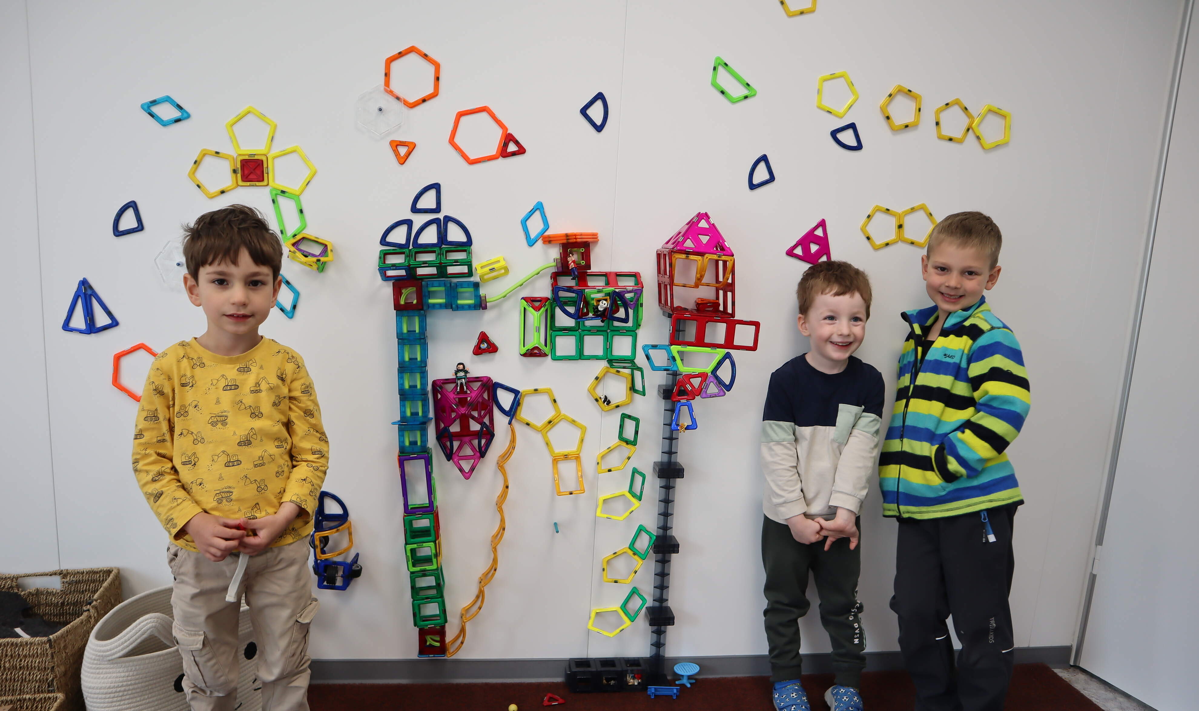 Kindergartenkinder vor einer bunt gestalteten Wand