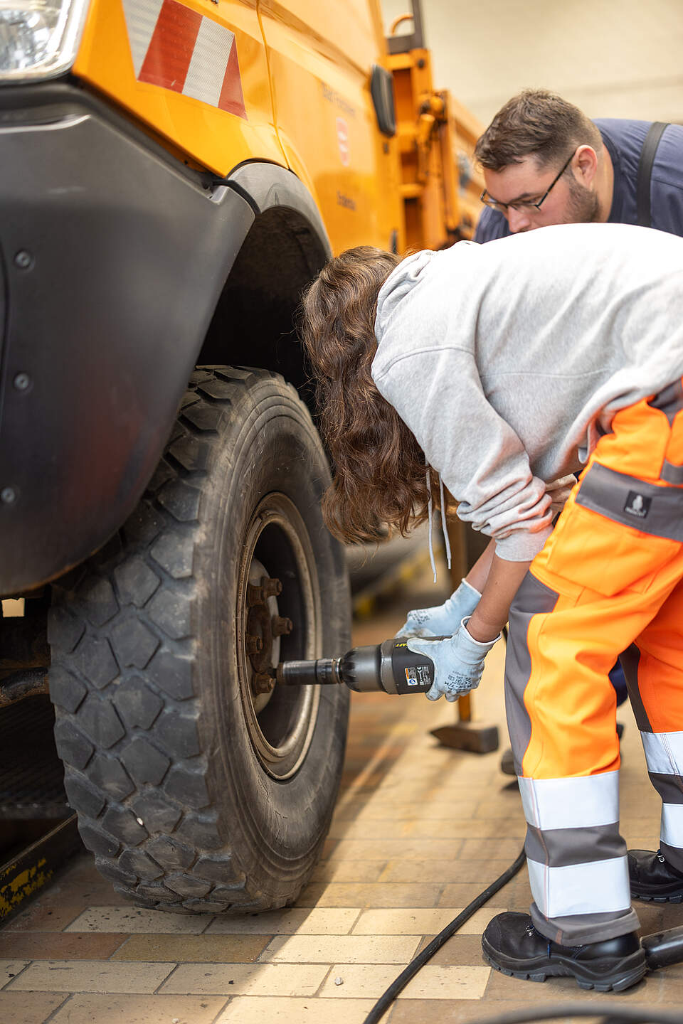 Mitarbeitende im Bauhof bei der Arbeit an einem Kfz