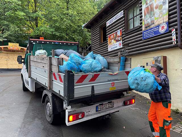 Ein Kleinfahrzeug wird mit Müll beladen