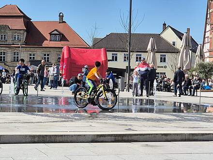 Kinder fahren mit dem Fahrrad durch das Fontänenfeld