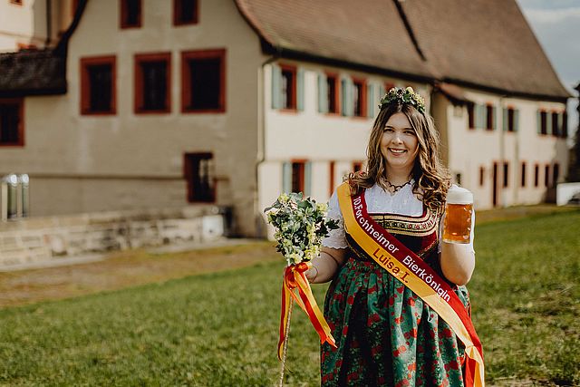 Die Bierkönigin vor historischem Hintergrund