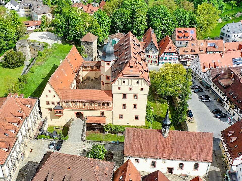 Luftbildaufnahme mit der historischen Kaiserpfalz im Bildmittelpunkt umgeben von Fachwerkhäusern. Links im Bild sieht man einen Ausschnitt des Stadtparks.