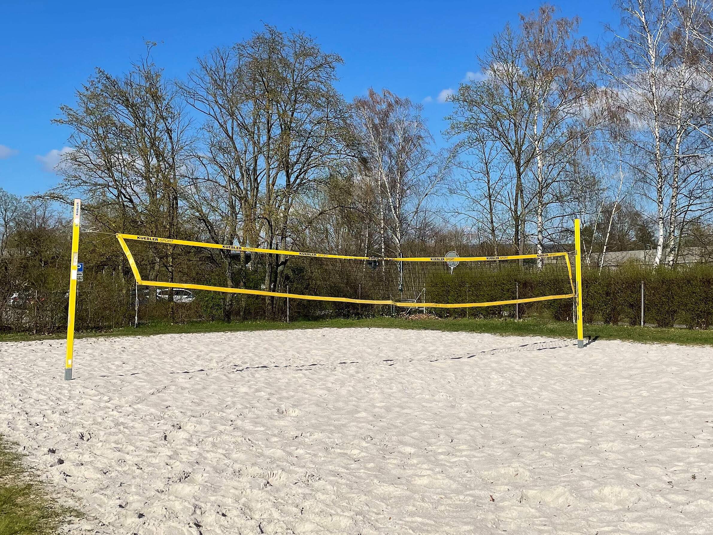 Beachvolleyballfeld Ein Beachvolleyballfeld mit großen Bäumen im Hintergrund.