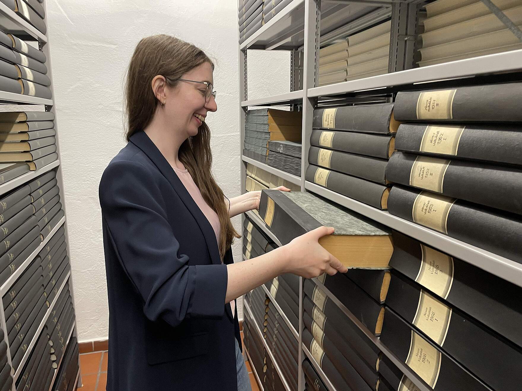 Stadtarchivarin Miriam Mulzer Stadtarchivarin Miriam Mulzer bei der Arbeit zwischen den hohen Regalen des Forchheimer Stadtarchivs, die mit Archivalien gut gefüllt sind.