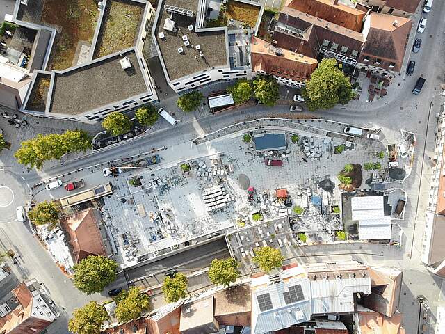 Luftbildaufnahme Paradeplatz Forchheim Eine Luftbildaufnahme zeigt die Umbaumaßnahmen auf einem großen Stadtplatz mit Pflasterarbeiten, Baumaterial und neuen Bäumen.