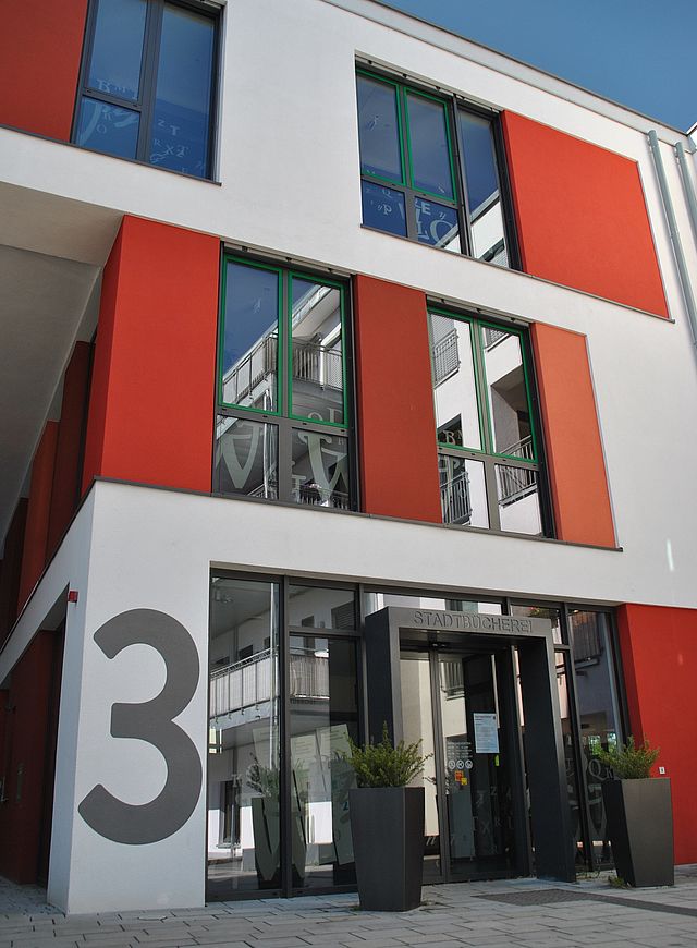Außenansicht des zweistöckigen modernen Gebäudes mit roten Fassadenelementen