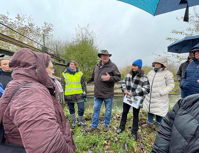 Forchheims Wassermanagerin Julia Schrade (Bildmitte mit Warnweste) mit der Besuchergruppe aus dem Landkreis Weißenburg-Gunzenhausen und den Fachleuten vom Wasserwirtschaftsamt Ansbach an einem Wehr im Gebiet der Forchheimer Wässerwiesen.