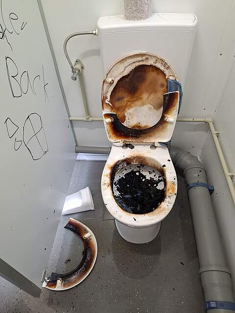 Zerstörte Toiletten auf der Sportinsel Eine verwüstete Toilettenanlage mit herausgerissenem Klopapier aus der Halterung, verstopften Leitungen und abgefackelter Klobrille auf der Sportinsel.