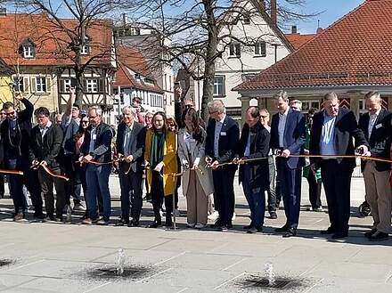 Feierliche Eröffnung der Wasserspiele am Paradeplatz, bei der mehrere Personen ein Band durchschneiden