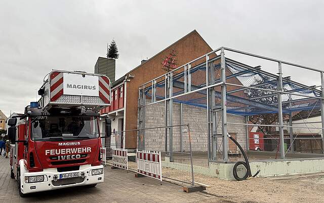 Richtfest an der neuen FFW Gerätehalle in Forchheim Ein Feuerwehrauto steht neben einer Halle, die sich noch im Aufbau befindet, mit einen Bäumchen zum Richtfest geschmückt.e, Forchheim.