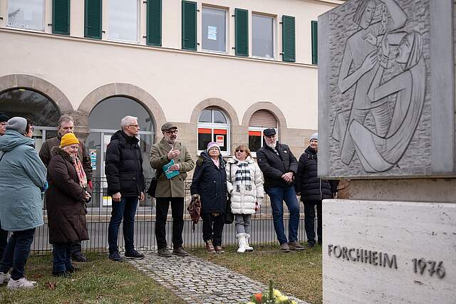 Personen vor einen Denkmal in Forchheim, bei der Kranzniederlegung.
