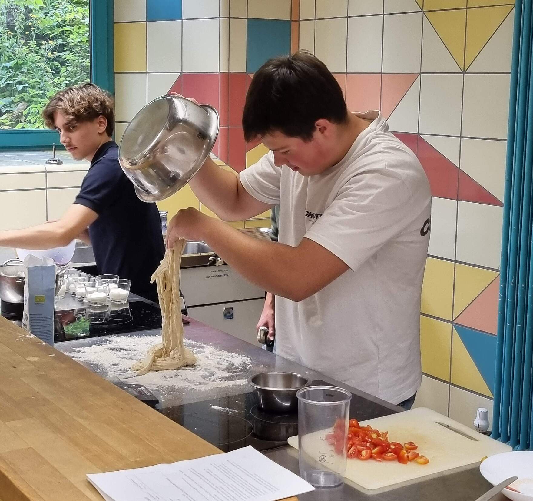 Azubis in einer Küche beim Zubereiten von Essen.