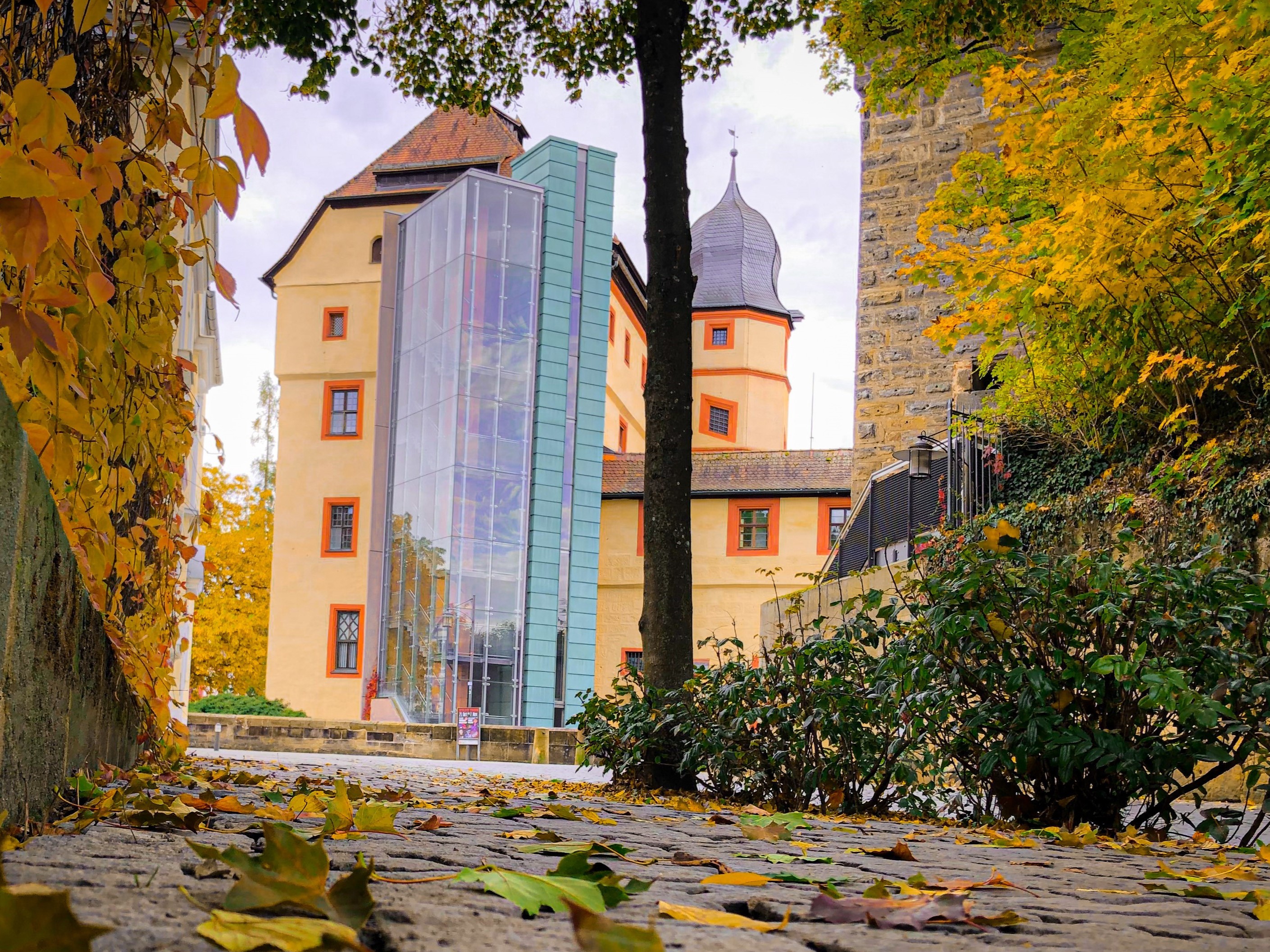 Herbstaufnahme von der Rückseite der historischen "Burg" Kaiserpfalz, die vor einigen Jahren mit einem modernen gläsernen Aufzug ausgestattet wurde.