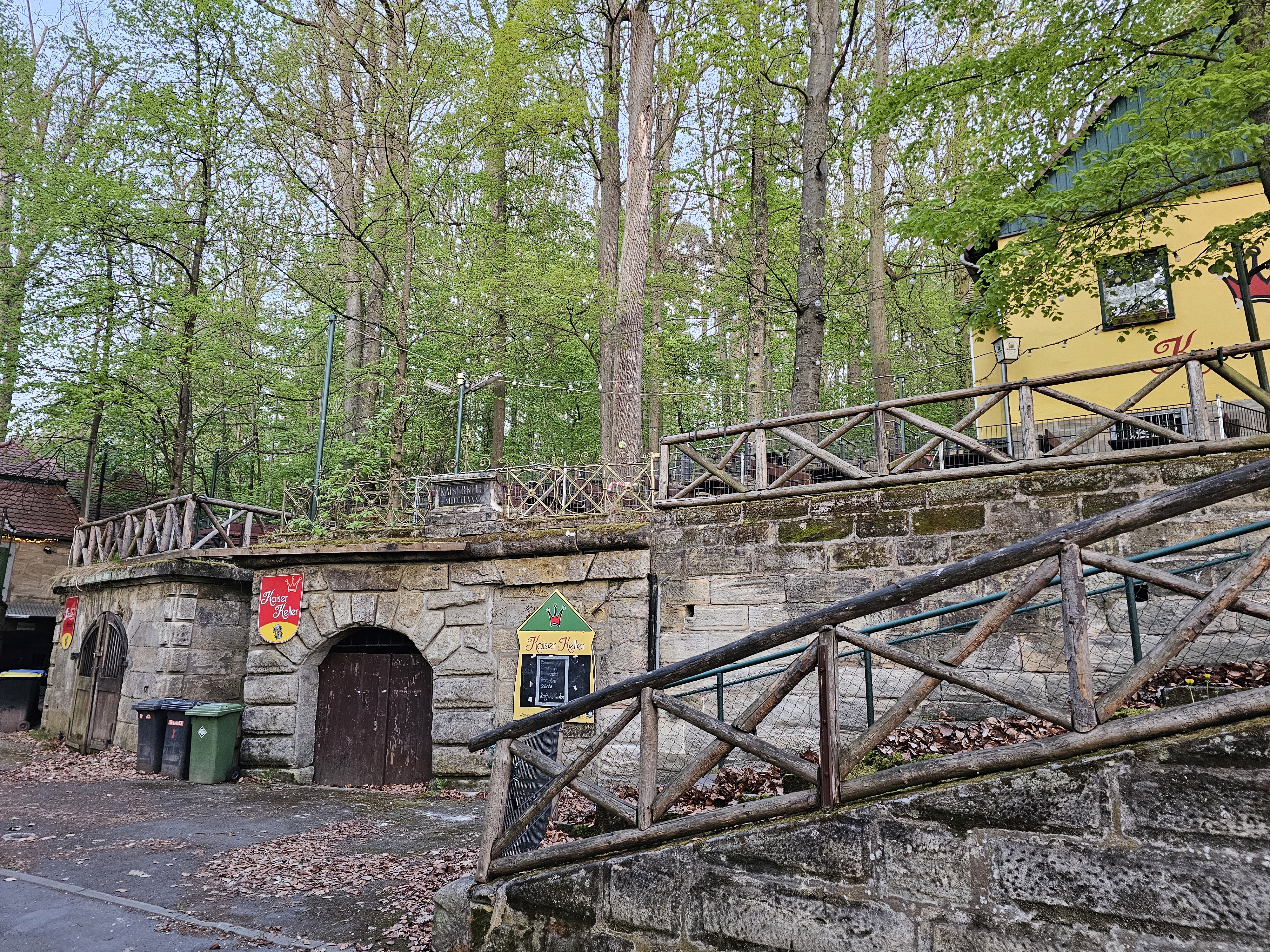 Kaiser-Keller Aufgang zum Kaiser-Keller im Forchheimer Kellerwald, mit Sandsteinmauern, Eingangstor zum Bierkeller für Lagerungen, umgeben von Bäumen.