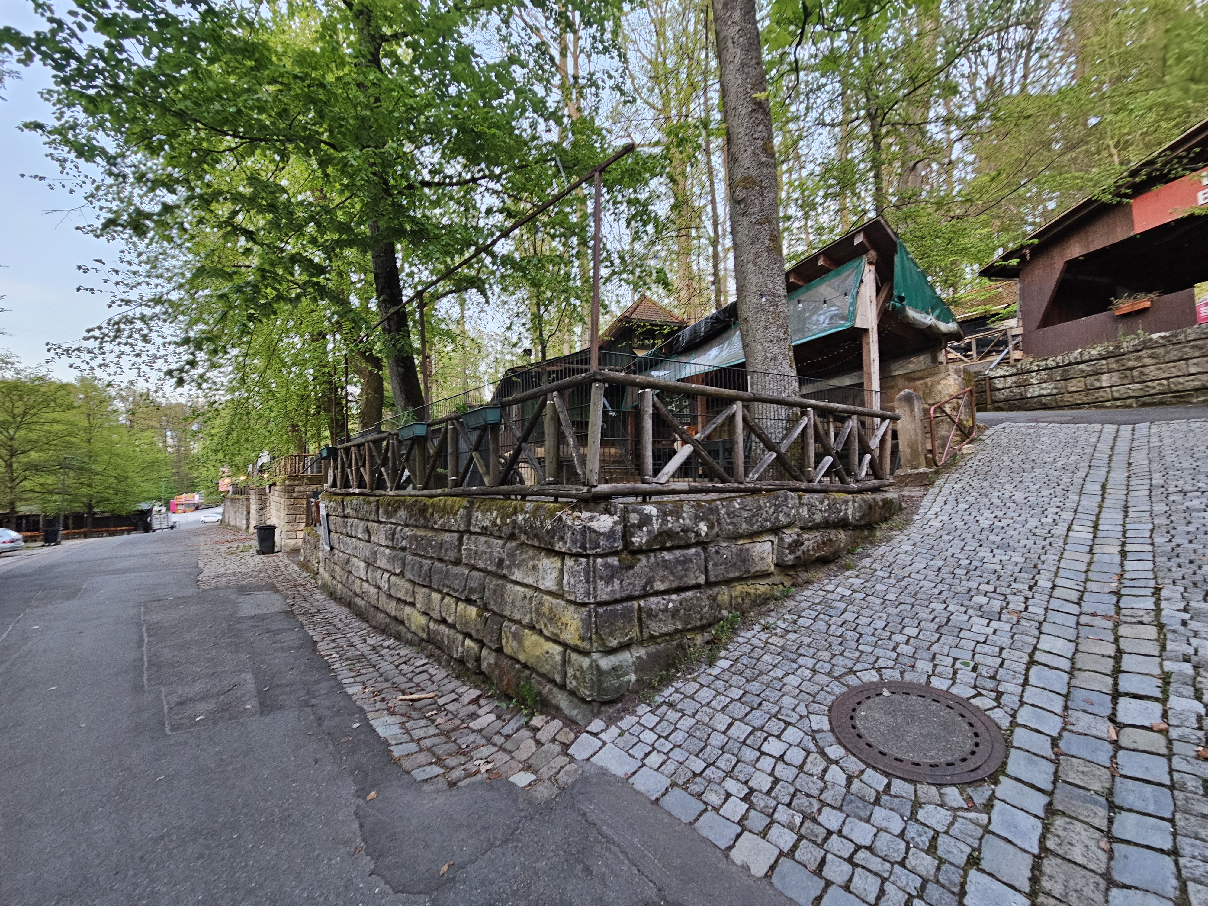 Rappenkeller Rappenkeller-Ansicht vom Hauptweg mit Sandsteinmauer und überdachten Sitzplätzen im Forchheimer Kellerwald.
