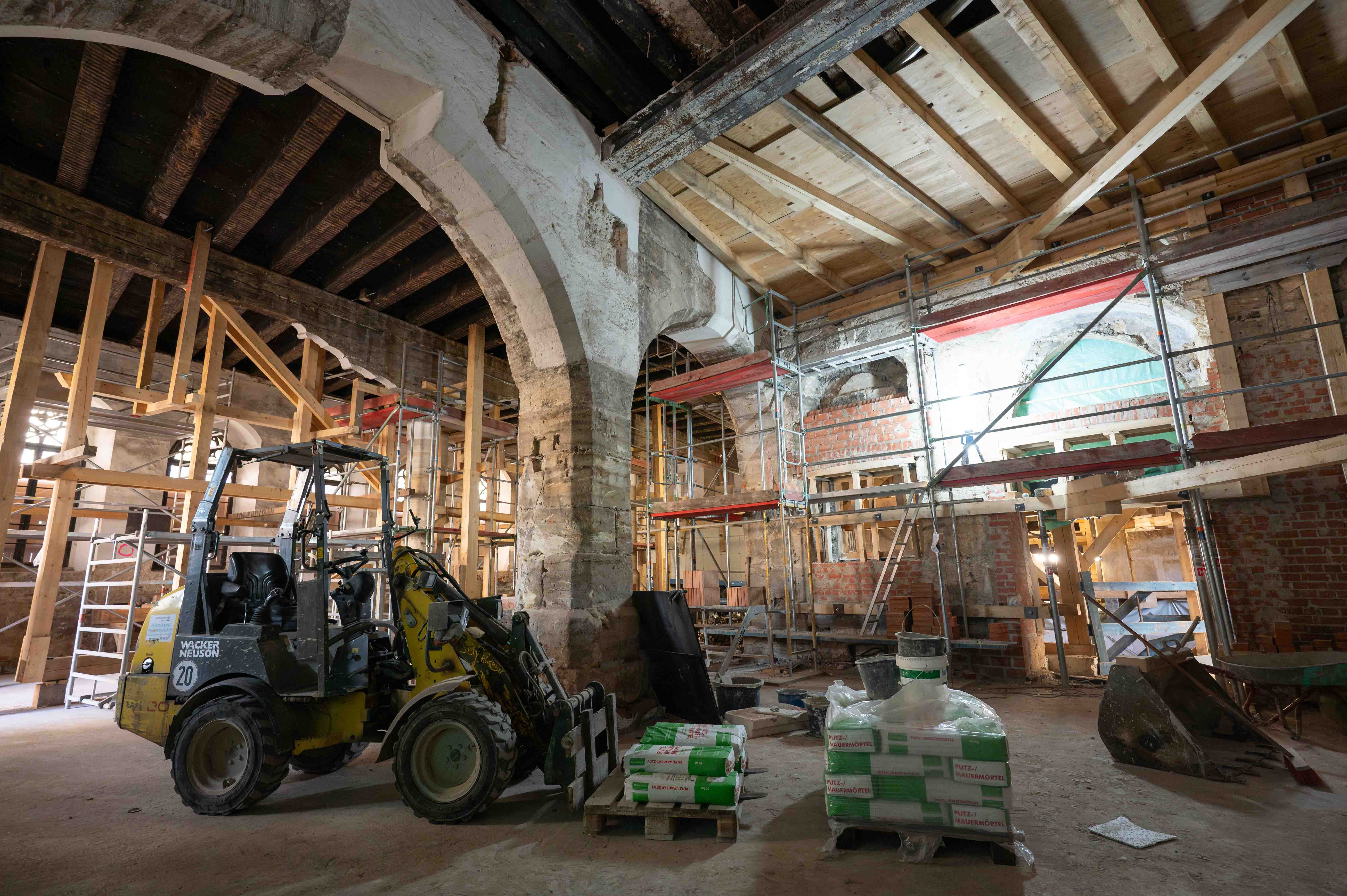 Bild vom Erdgeschoss der Baustelle mit Bagger im Innenbereich