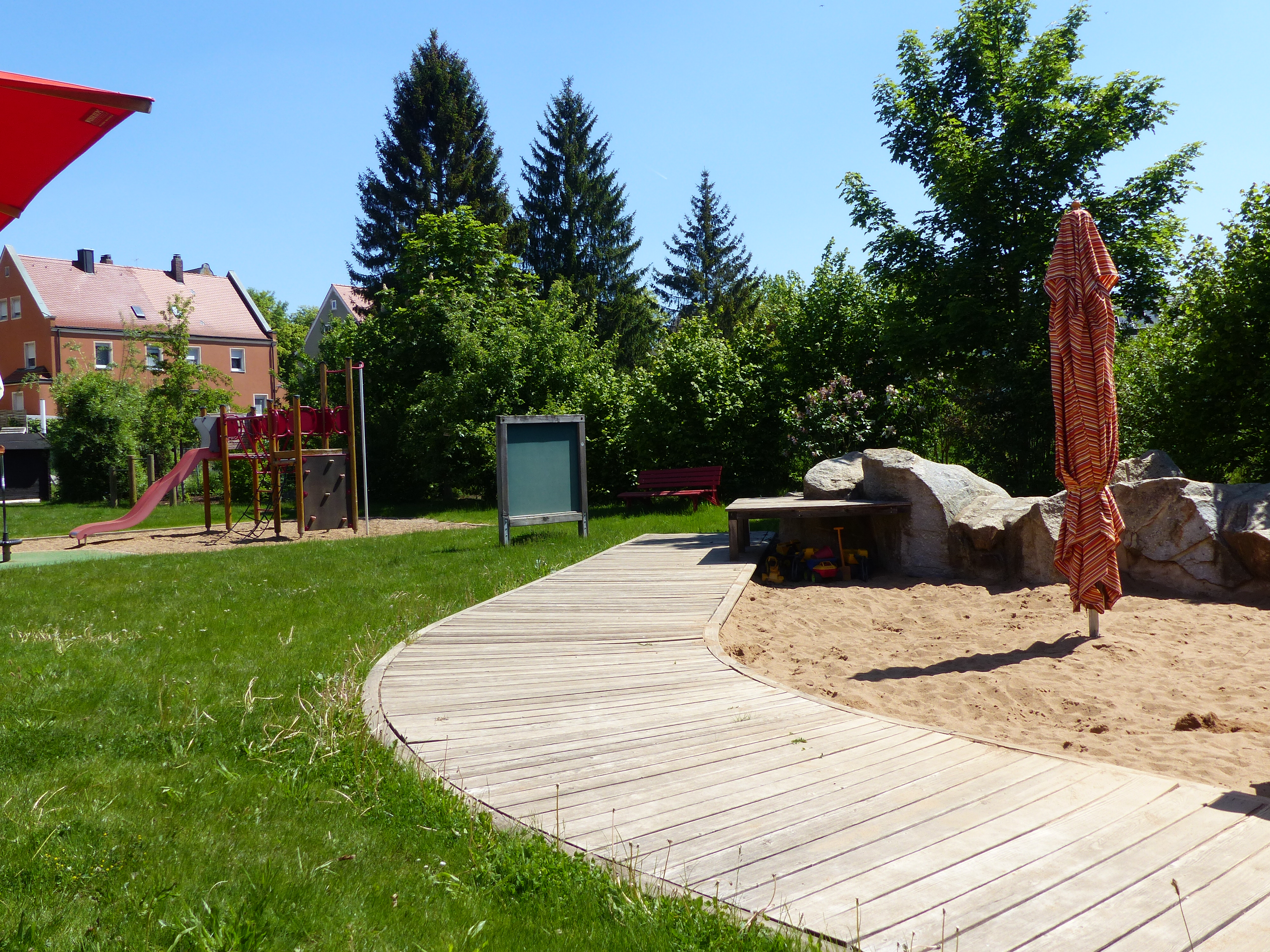 Der Außenbereich einer städtischen Kita mit Sandkasten