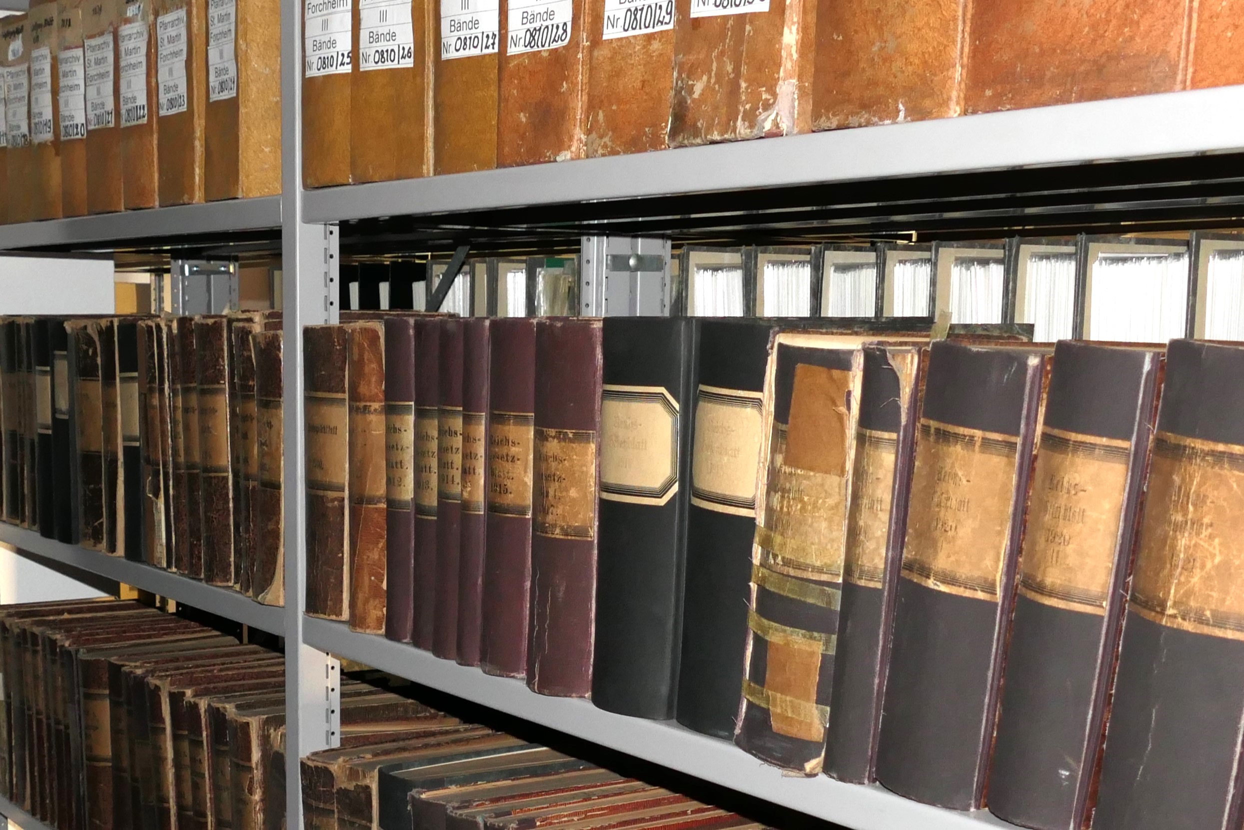 Bänder und Ordner in Schwerlastregalen eines Archivs.